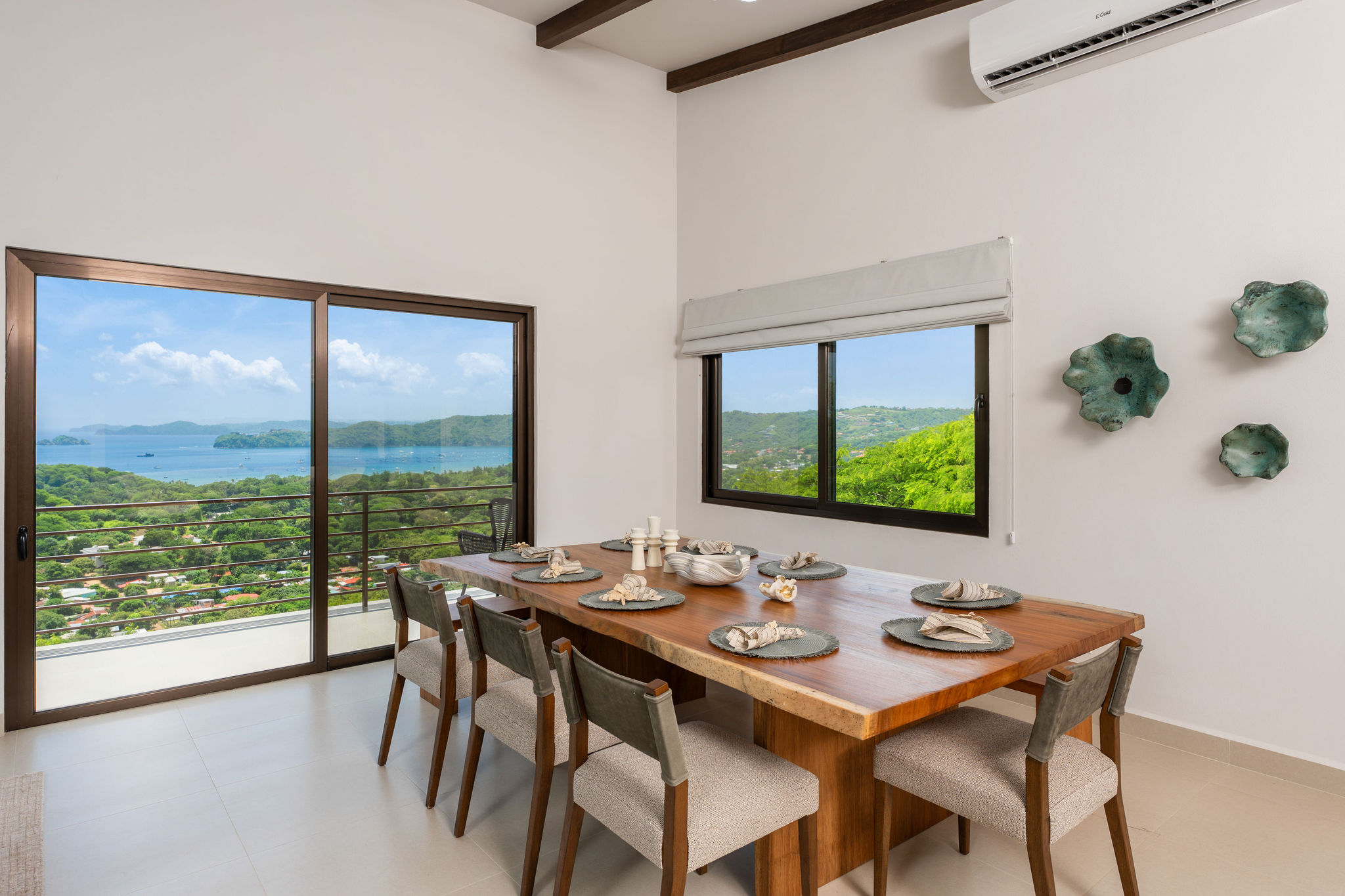 Dining table beside large windows with coastal views