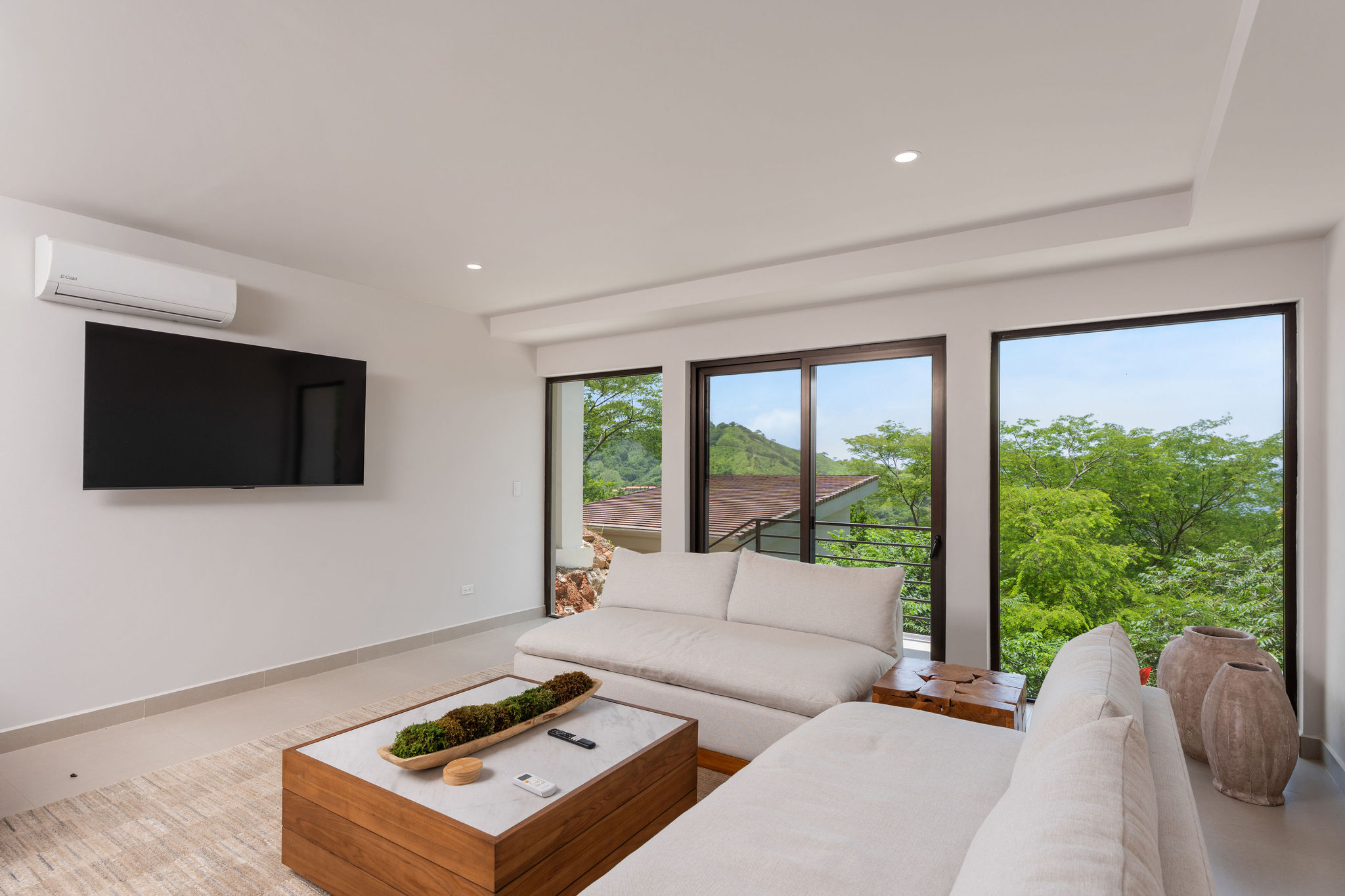 Family room with television and views of tropical greenery