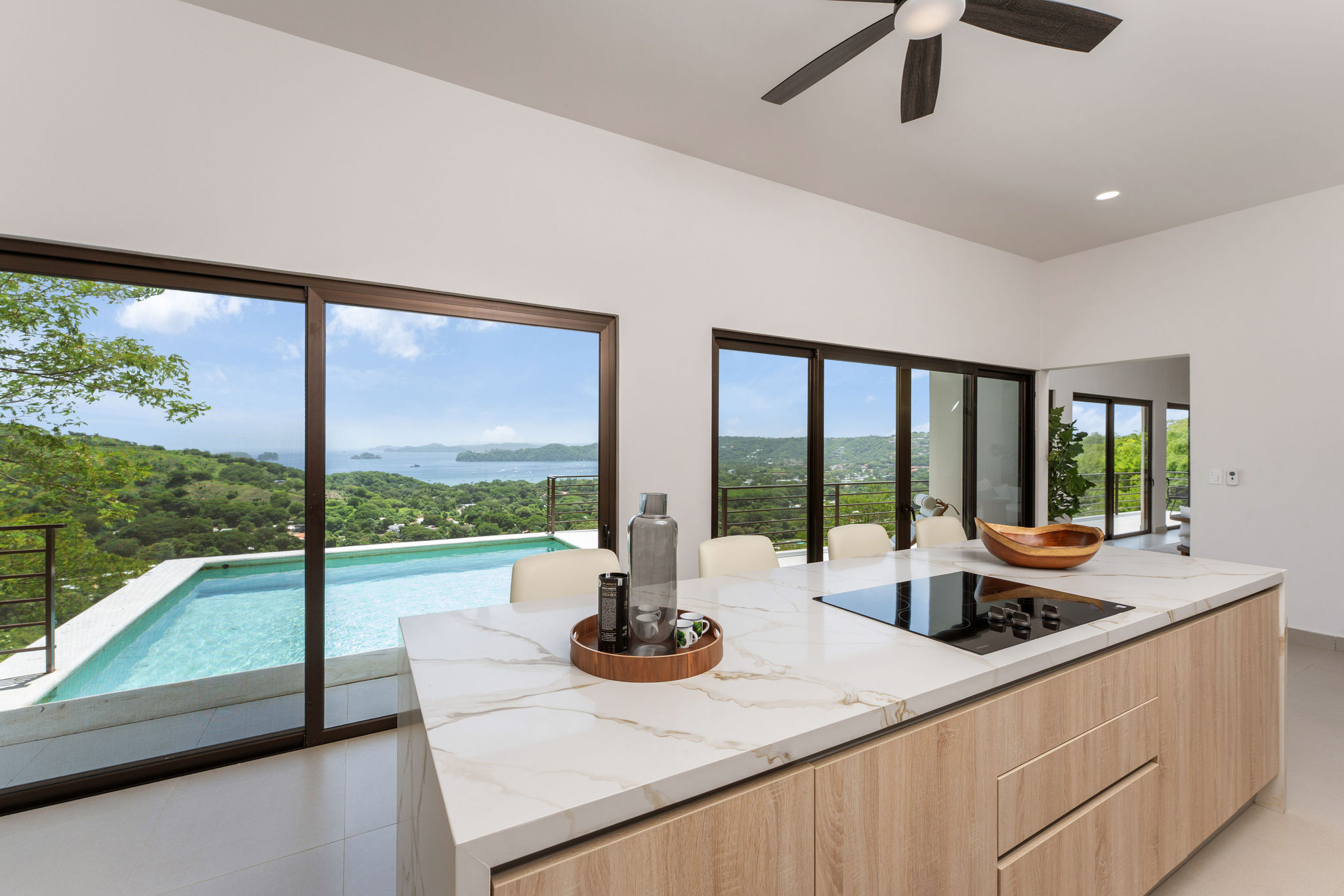 Kitchen island and sliding doors opening toward the pool and view