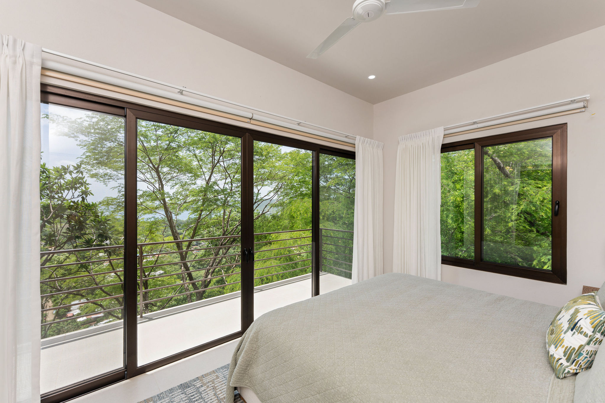 Bedroom with a balcony and greenery outside