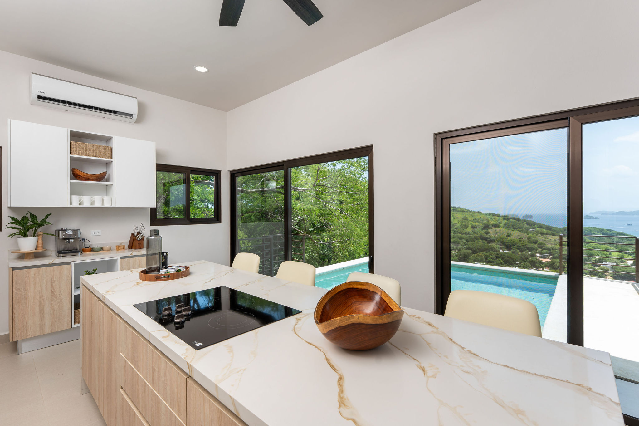 Kitchen island, breakfast seating, and pool views